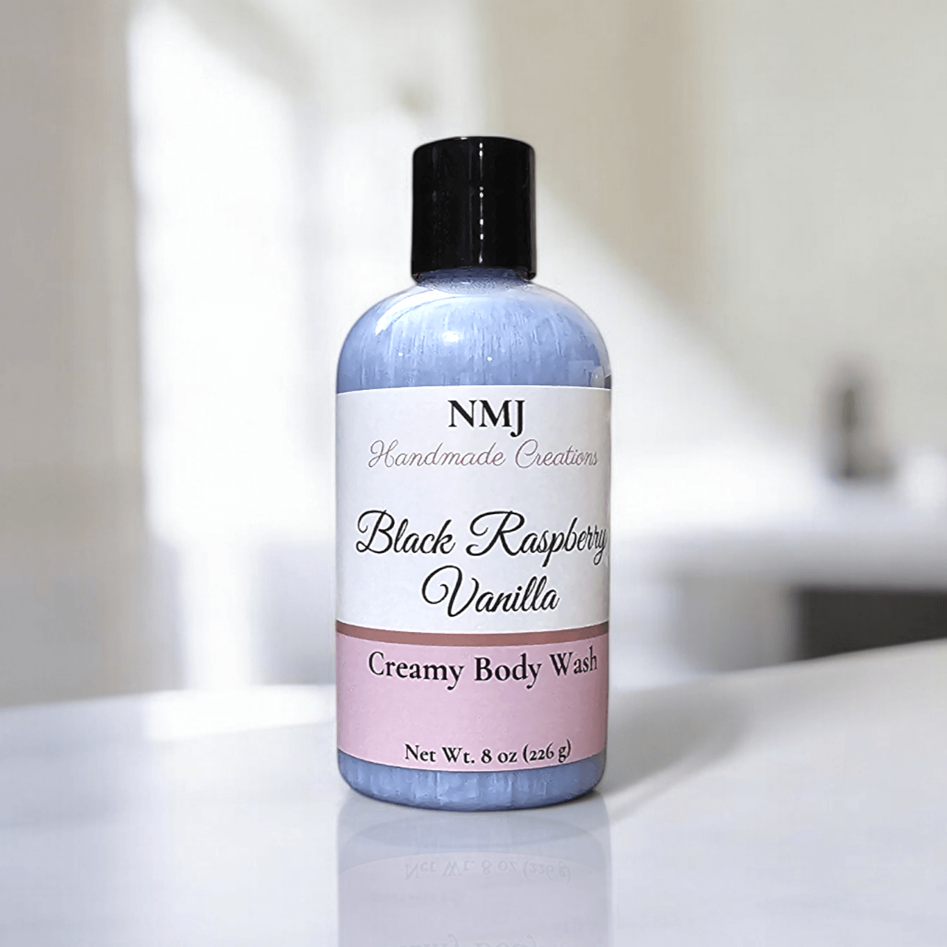 Creamy Body Wash by NMJ with Black Raspberry Vanilla scent, 8 oz bottle on a white surface.