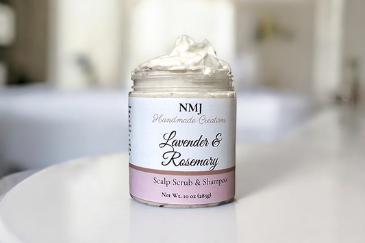 A jar of NMJ Handmade Creations' Lavender & Rosemary Scalp Scrub & Shampoo, topped with a luxurious white creamy texture, presented in a soothing bathroom ambiance.