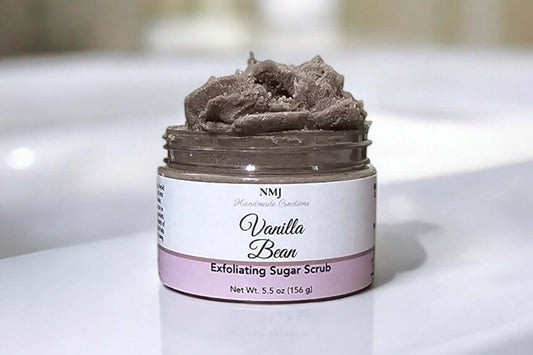 Exfoliating Sugar Scrub Vanilla Bean by NMJ, 5.5 oz, offers radiant skin with hydrating oils and a sweet aroma.