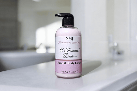 An 8 oz bottle of NMJ Handmade Creations' Endlessly In Love hand and body lotion, presented in a soft pink bottle with elegant white and gray labeling, positioned on a pristine countertop.